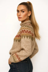 Woman wearing a beige knit sweater with multicolor Nordic pattern